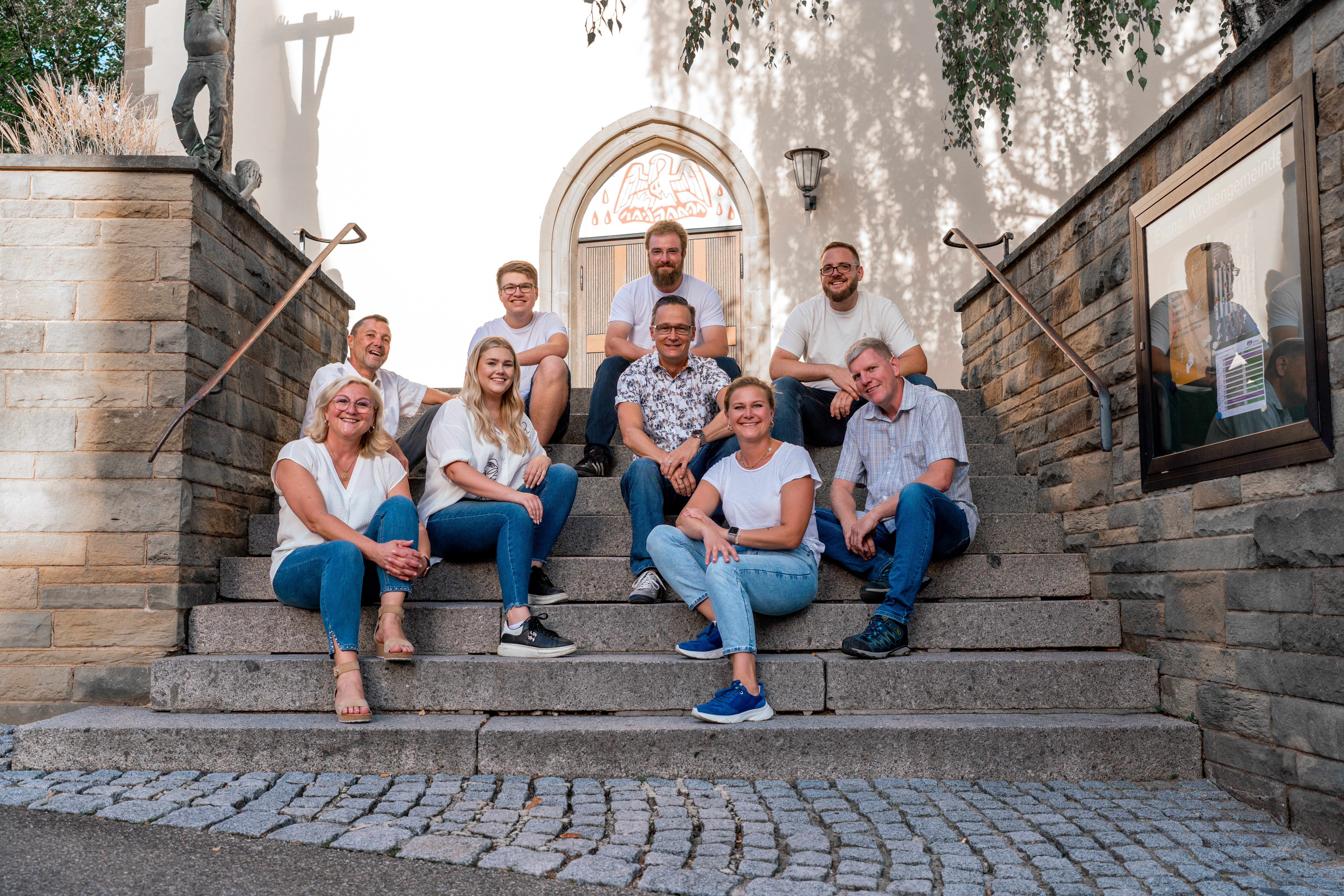 Das Wirtschaftsteam auf der Treppe der Kirche in Löchgau mit neun abgebildeten Mitgliedern
